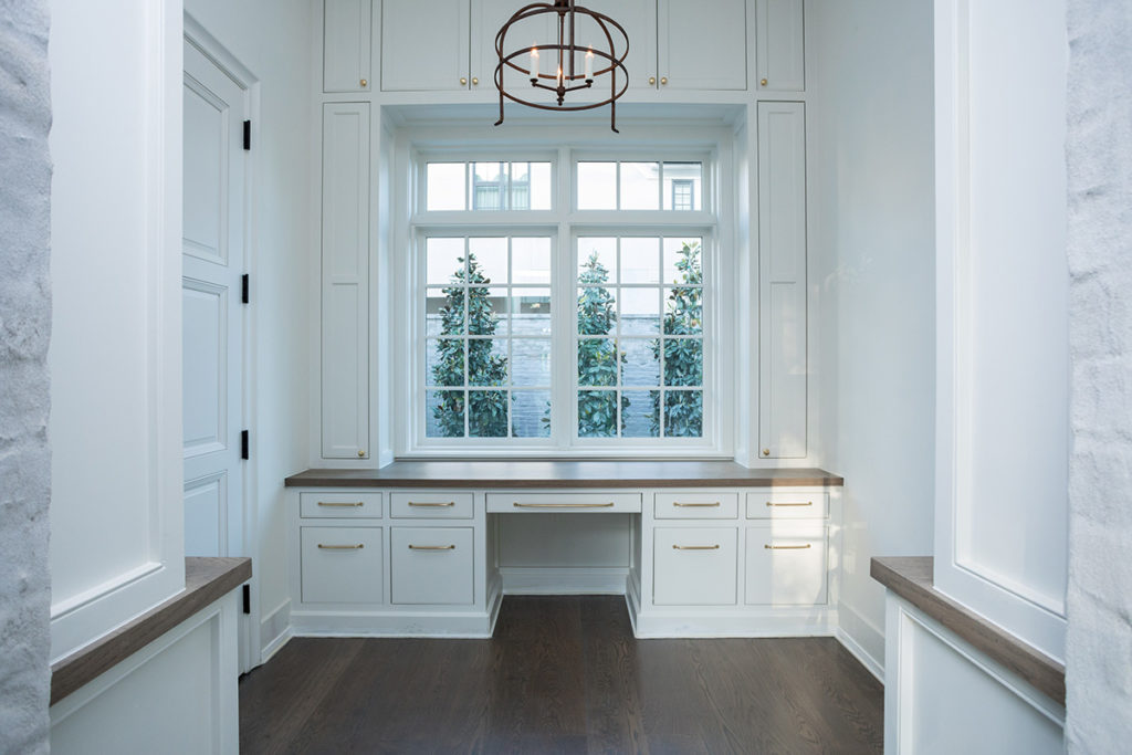 home office with built in desk, chandelier and large withdow